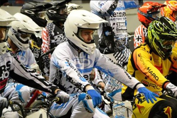 Cameron Moore wearing a white bikers helmet and jersey at a BMX race.